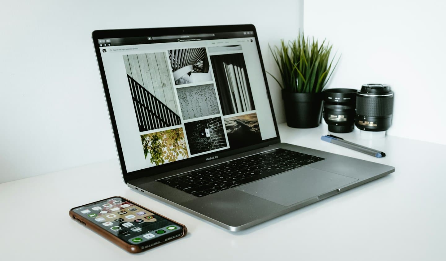 Portátil sobre un escritorio blanco mostrando una web de galería de fotos.