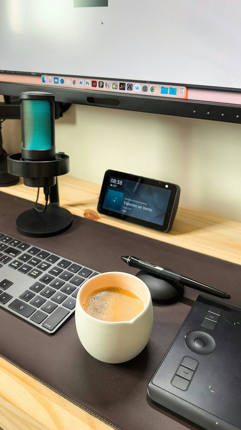 Escritorio de computadora moderno con electrónica y una taza de café.